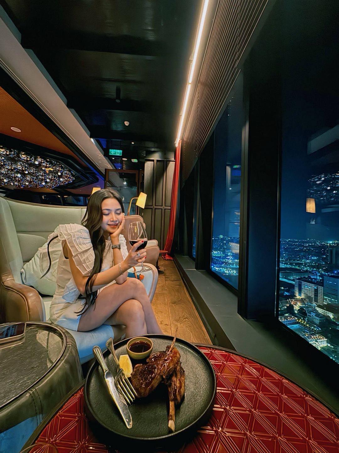Lina Liu enjoying an evening meal beside a city view